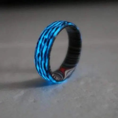 Blue glow in the dark wedding ring made from carbon fibre and inner fordite wedding band