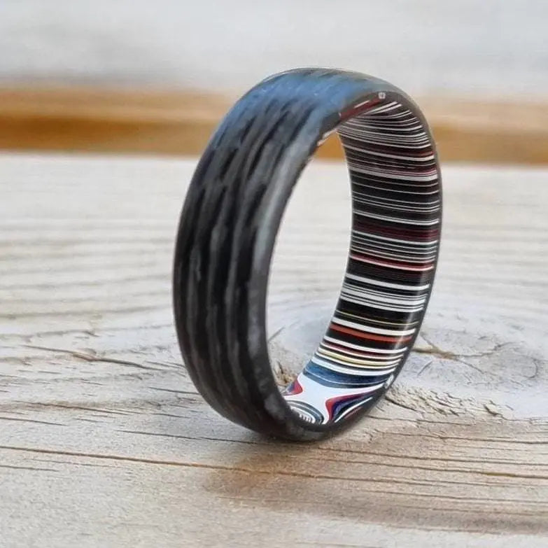 Carbon fibre ladies and mens wedding ring with fordite material inlay